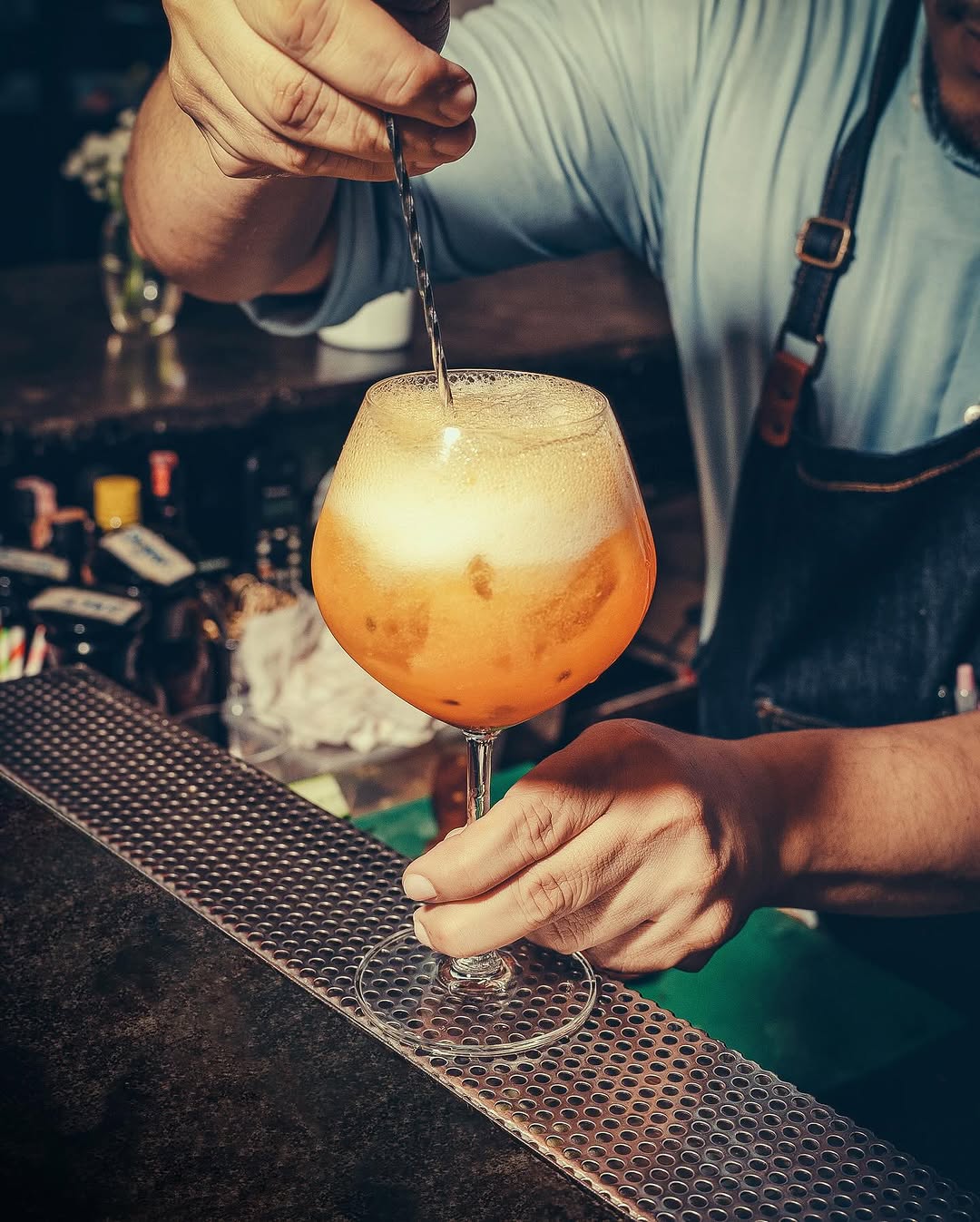 A bartender stirring a glass of cocktail